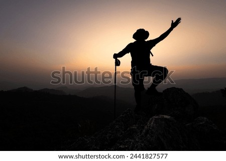 Climber success, silhouette achievements successful arm up man is on top of hill celebrating success with sunrise.