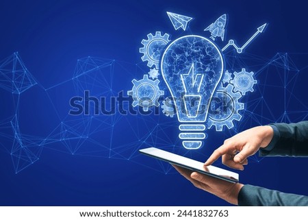 Close up of male hands using smartphone with glowing blue lightbulb, cogwheel and arrow hologram on polygonal background. Innovation and creative idea concept