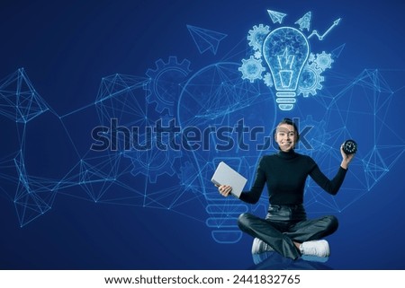 Attractive smiling young woman sitting on floor with notepad, clock and glowing blue lightbulb, cogwheel and arrow hologram on polygonal background. Innovation and creative idea concept