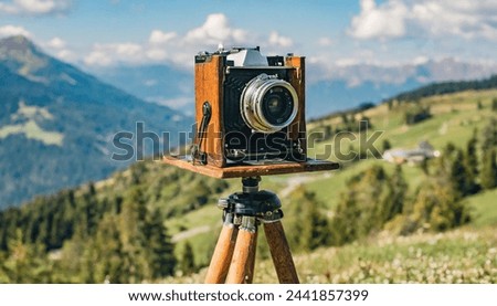 old antique bellows film camera on wooden tripod taking picture of landscape, outdoors photography, close up front side view of camera