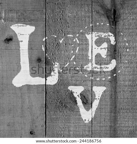 A background of wood with love text painted on it black and white