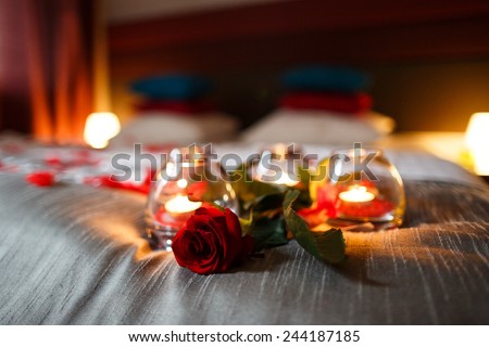 Romantic Valentines Day evening. Romantic night. Rose and candles on bed. Royalty-Free Stock Photo #244187185