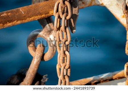 Blue sea background and rusty metal chain. Rusty chain. Horizontal photo. No people, nobody. 
