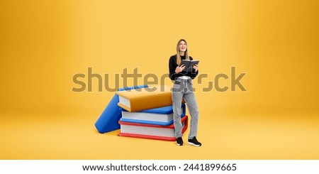 Smiling woman with notebook in hands, standing near stack of cartoon books. Copy space empty colored background. Concept of education, student, knowledge and literature