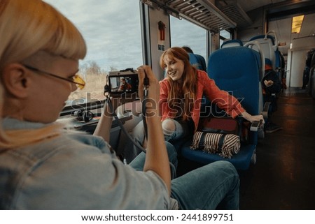 Women are taking turns snapping photos of each other, enjoying the train ride Royalty-Free Stock Photo #2441899751
