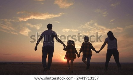 people in the park. big family silhouette walk at sunset. mom dad and daughters walk holding hands in park. large family kid dream concept fun. parents and children walking back silhouette