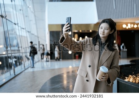 Professional Woman Capturing a Selfie in Office Environment