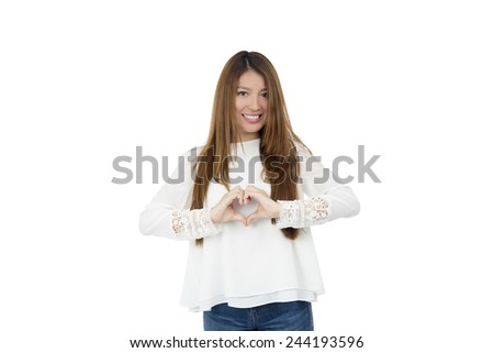 Beautiful young woman doing a heart gesture against a white background