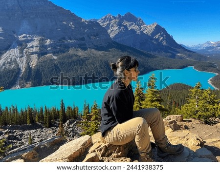 Pretty woman with sunglasses relaxing, resting after a walk on a sunny day by Peyto Lake, in Canada.
