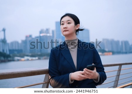 Confident Young Professional with Smartphone by River