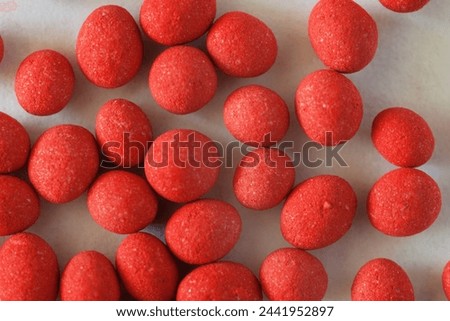 Close-up of carrot seeds in red dragee shell. Modern way to protect seeds from pests and stimulate seedling germination. Growing organic vegetables concept. Flat lay, macro, top view Royalty-Free Stock Photo #2441952897