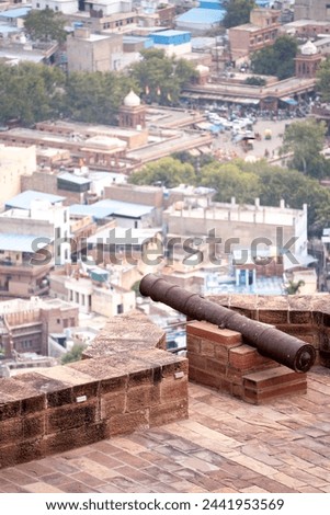Ancient iron cannon set on the walls of a fort looking out over the city of jodhpur, jaipur, udaipur showing the defences of the ancient Rajput kings Royalty-Free Stock Photo #2441953569