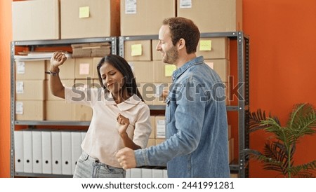Two workers man and woman standing together dancing at office