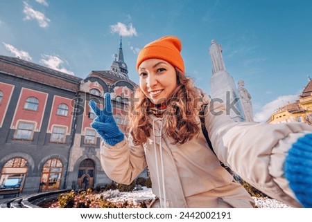 Tourist girl taking selfie photo against Subotica town hall, while travelling in Serbia