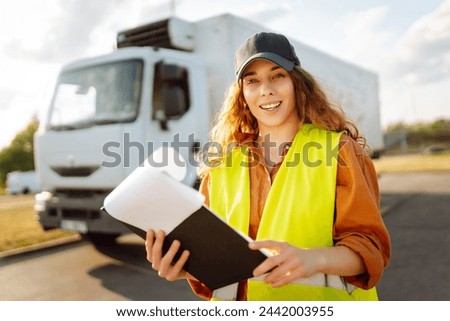 Woman truck driver standing by vehicle doors. Transportation service. Truck female driver job. 