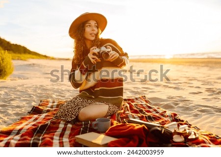 Young Woman at the Beach with Vintage Camera. Picnic, relax, weekend.