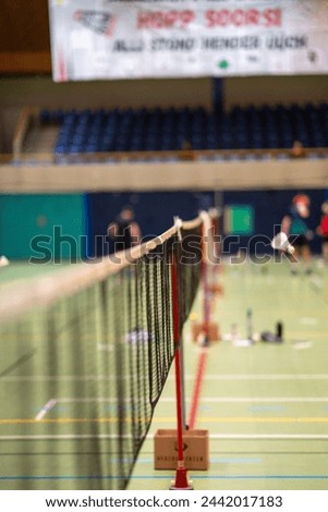 Picture of a shuttlecock flying over a badminton net