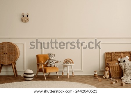 Minimalist composition of kids room interior with velvet orange armchair, braided baskets, round rug, white stool, beige wall with stucco and personal accessories. Home decor. Template.