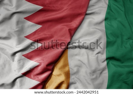 big waving national colorful flag of cote divoire and national flag of bahrain. macro
