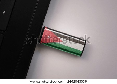 usb flash drive in notebook computer with the national flag of jordan on gray background. concept