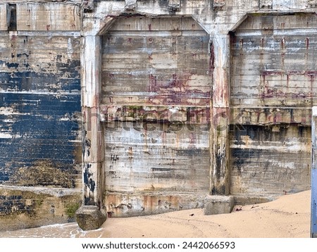 Vintage concrete structure walls on sand beach of Monterey Bay in cannery district Royalty-Free Stock Photo #2442066593