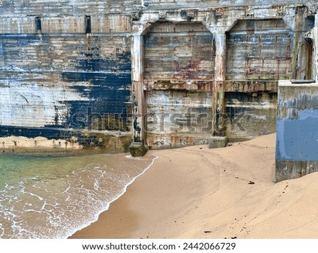 Vintage concrete structure walls on sand beach of Monterey Bay in cannery district Royalty-Free Stock Photo #2442066729