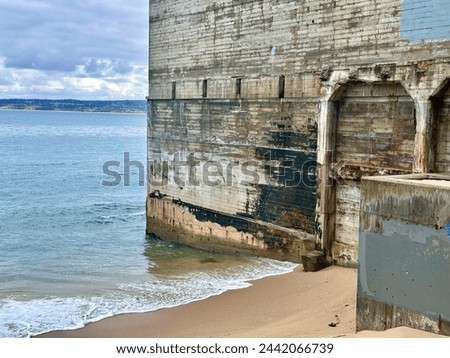 Vintage concrete structure walls on sand beach of Monterey Bay in cannery district Royalty-Free Stock Photo #2442066739