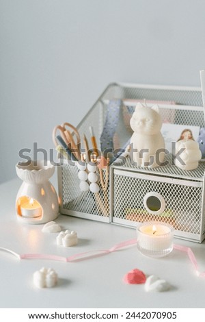 A charming workspace accented with a whimsical cat figurine, elegant stationery, and warm candlelight, exuding tranquility and style. Royalty-Free Stock Photo #2442070905
