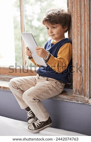Home, tablet and young kid on app, internet and game on website for learning by windowsill. Technology, child and boy in house for education, relax and watch cartoon online on digital electronics