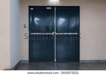 View of the closed door of the evacuation exit from the building during a fire or other cataclysm. Emergency fire exit from the building. Closed emergency exit door, for quick evacuation