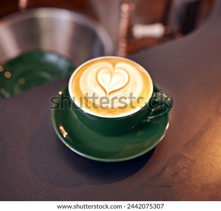 Coffee, cup and latte with art for creativity, closeup of cappuccino or caffeine drink on counter with pattern. Warm beverage, foam and milk with heart design, hospitality and table service at cafe