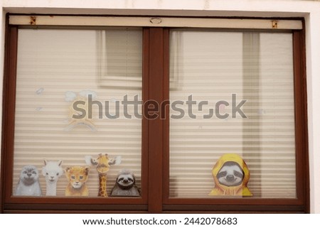 Painted animals looking out of the window: Panda, sloth, giraffe, lion cub, llama, otter