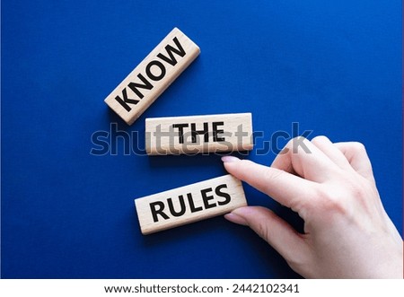 Know the rules symbol. Wooden blocks with words Know the rules. Beautiful deep blue background. Businessman hand. Business and Know the rules concept. Copy space.