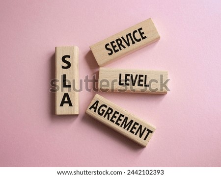 SLA - Service Level Agreement. Wooden blocks with word SLA. Beautiful pink background. Business and Service Level Agreement concept. Copy space.