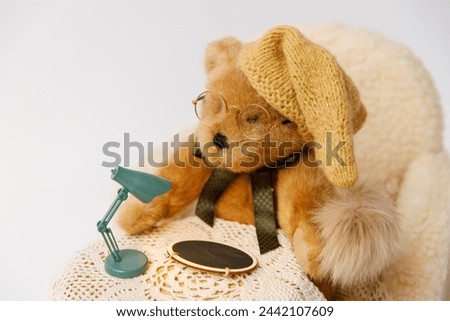 Shoot set up with sofa, table and toy bear with hat and glasses for newborn on white background. Photo zone for a photo session of newborns. 