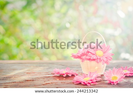  Flowers in a basket  on a wooden with bokeh background in a vintage retro style, with the sunrise, for the day of love, Valentine's Day. Royalty-Free Stock Photo #244213342