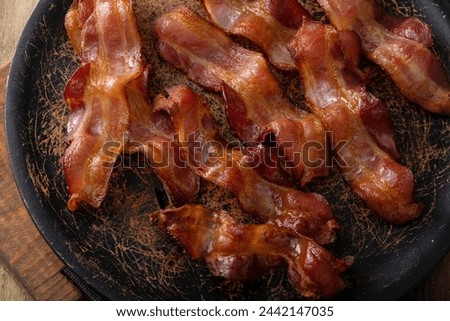 Cooked bacon on a serving platter skillet ready to eat for breakfast Royalty-Free Stock Photo #2442147035