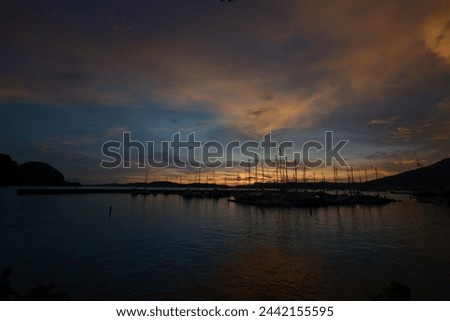 a picture of an evening view of a harbor where a yacht is anchored with beautiful and peaceful clouds