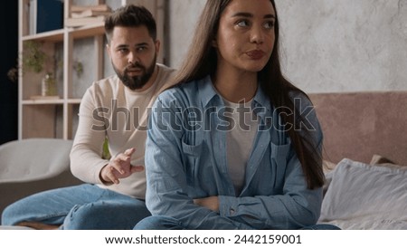 Offended upset woman girlfriend offense to boyfriend marriage problem family quarrel in bedroom Caucasian sad couple sit separately on bed after conflict relationship breakup guilty man try to apology Royalty-Free Stock Photo #2442159001