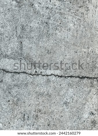 a photography of a fire hydrant sitting on the side of a cement wall.