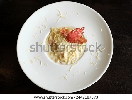 Picture of delicious
Spaghetti Carbonara with Bacon Ham Parsley 
and mushroom cream sauce with ham 
Ready to serve on a white ceramic plate.
Traditional Italian food, top view