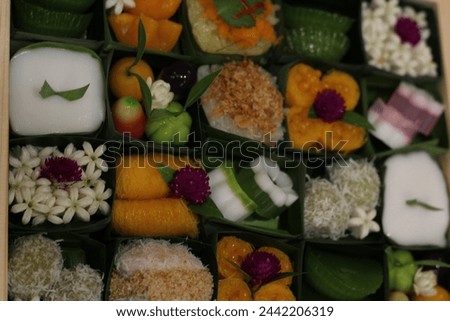 Picture many Thai Desserts big set packet in banana leaf by collocate and colorful beautiful garnish . Which have 
 a valuable  for adult gift or meeting party .