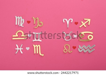 Zodiac signs compatibility on pink background, flat lay Royalty-Free Stock Photo #2442217971