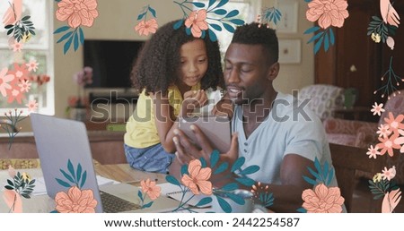 Image of flowers over happy african american father and daughter using tablet and laptop at home. family life, childhood, love and care concept digitally generated image.