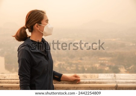 Asian woman wearing an N95 mask for protect bad air pollution. PM2.5 levels meaning the air quality posed a health hazard. Royalty-Free Stock Photo #2442254809