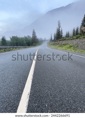 Road in the mountains in the fog, photo as background. Beautiful natural photo wallpaper.