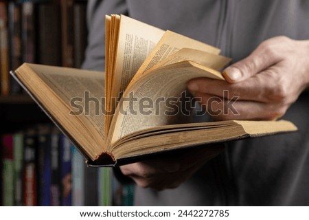 Man reading. Book in his hands. Close up.