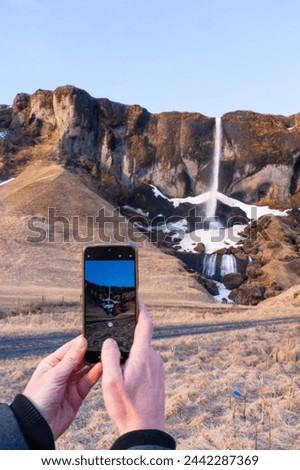 Smartphone taking a photo of a waterfall in Iceland