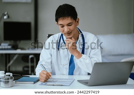 Male doctor working on desk with laptop computer and paperwork in the office. Medical and doctor concept.	