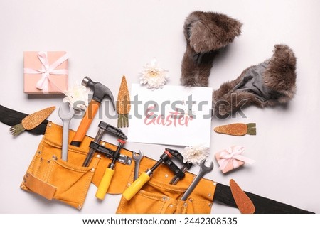 Composition with construction tools, greeting card, gifts and Easter decor on light background